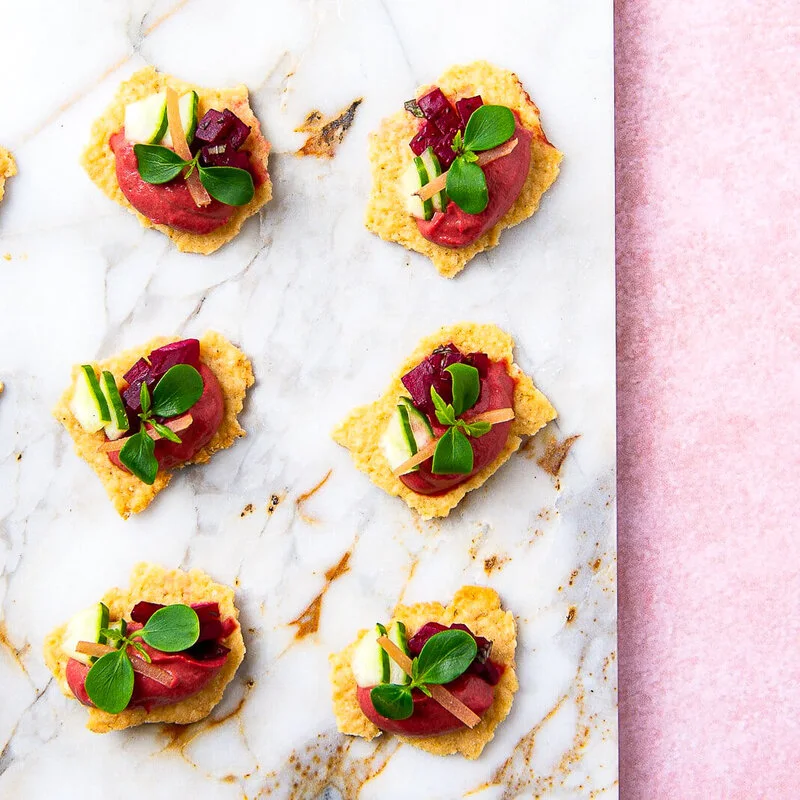 Beetroot hummus with crackers, cucumber and preserved lemon
