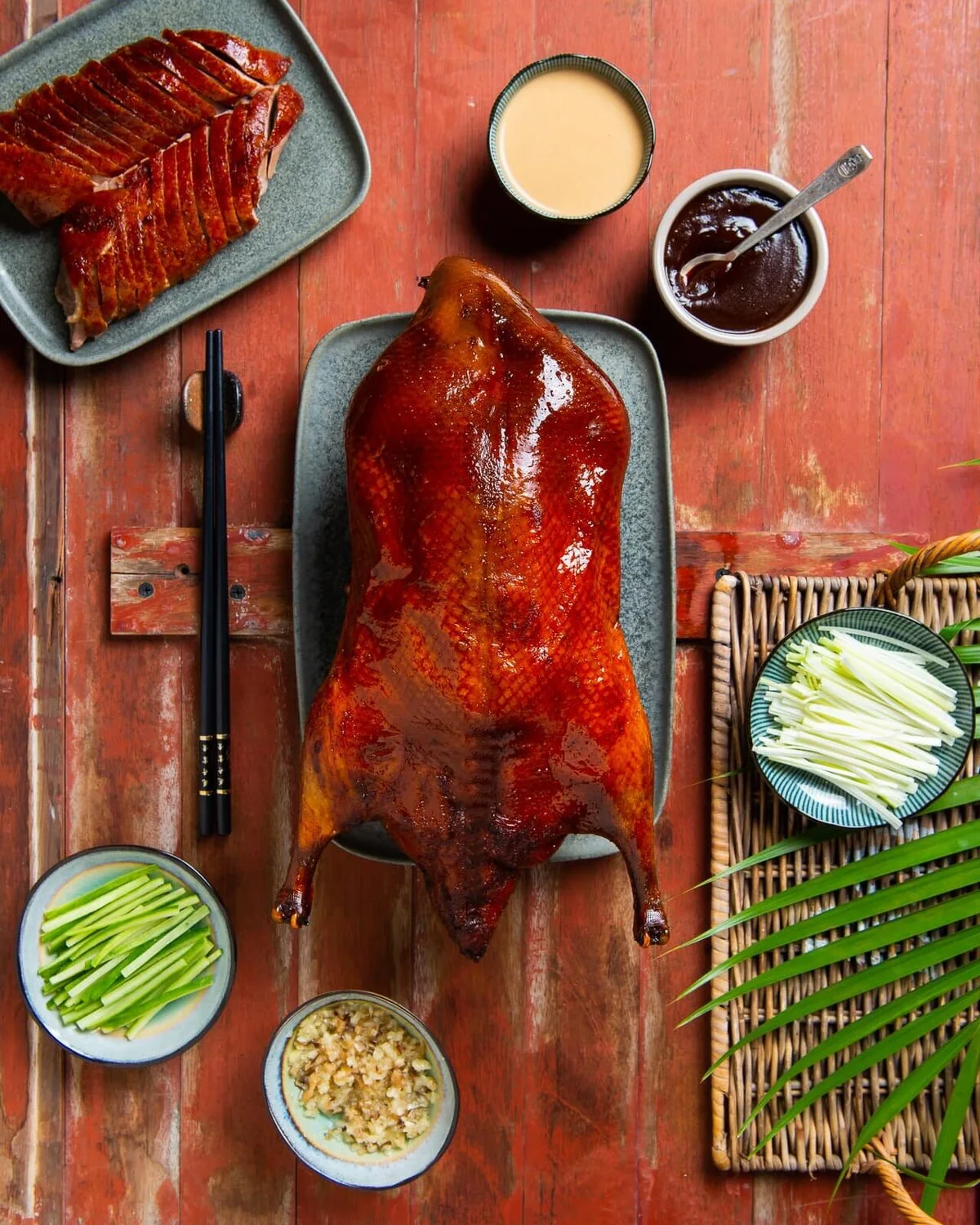 Peking duck with sliced portions, cucumbers, scallions and sauces.